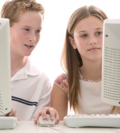 photo of two kids at computer screens