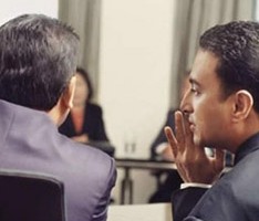 photo of company executives whispering