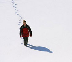 photo of woman walking in the snow