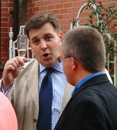 image of Simon holding a glass of champagne